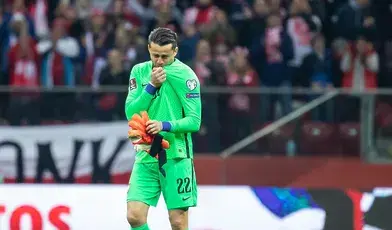 Łukasz Fabiański w reprezentacji Polski. Całuje Orzełka