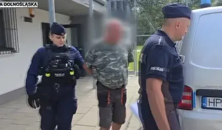 Policjanci prowadzą zatrzymanego mężczyznę podejrzanego o podszywanie się pod masażystę w sanatorium w Cieplicach