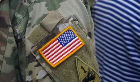 Amerykański żołnierz NATO w mundurze z flagą USA podczas dyskusji o obecności wojsk amerykańskich w Polsce