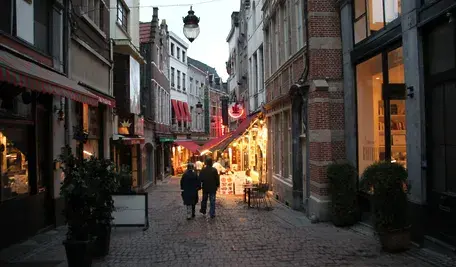 Ulica w centrum Brukseli z zabytkową belgijską zabudową, kamienicami, restauracjami i przechodniami. Spokojny obraz miasta w kontekście debaty o bezpieczeństwie i rosnącej przemocy narkotykowej.