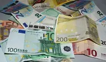 Banknoty euro o różnych nominałach rozłożone na powierzchni, symbolizujące pieniądze, emerytury i nielegalne pobieranie świadczeń. Fotografia ilustruje artykuł o mieszkańcu Treviso, który przez 10 lat pobierał emeryturę zmarłej matki i wyłudził 230 tysięcy euro.