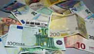 Banknoty euro o różnych nominałach rozłożone na powierzchni, symbolizujące pieniądze, emerytury i nielegalne pobieranie świadczeń. Fotografia ilustruje artykuł o mieszkańcu Treviso, który przez 10 lat pobierał emeryturę zmarłej matki i wyłudził 230 tysięcy euro.