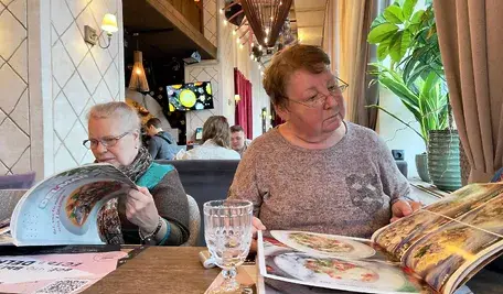 Panie w restauracji oglądają menu