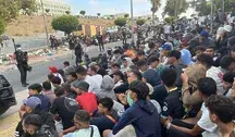 Migranci siedzący na ulicy w Ceucie