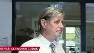 Dr hab. Sławomir Cudak w białej koszuli i krawacie podczas próby wejścia do gabinetu w Akademii Wymiaru Sprawiedliwości