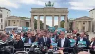 Konferencja prasowa polityków CDU przed Bramą Brandenburską w Berlinie w otoczeniu dziennikarzy i zwolenników z tabliczkami „Berlin bleibt stabil”