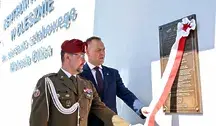 Prezydent RP Karol Nawrocki i kapitan rezerwy Wojska Polskiego Karol Cierpica podczas odsłonięcia tablicy w trakcie uroczystości nadania Centrum Kultury w Olesznie imienia sierż. sztabowego Michaela Ollisa.