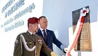 Prezydent RP Karol Nawrocki i kapitan rezerwy Wojska Polskiego Karol Cierpica podczas odsłonięcia tablicy w trakcie uroczystości nadania Centrum Kultury w Olesznie imienia sierż. sztabowego Michaela Ollisa.