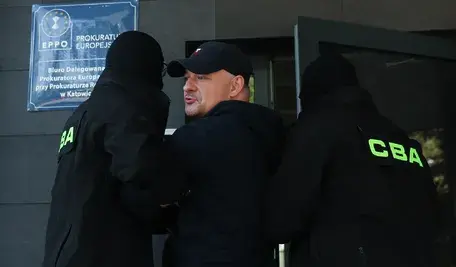 Poseł Wojciech Król (C) doprowadzany na przesłuchanie w katowickim biurze Prokuratury Europejskiej 