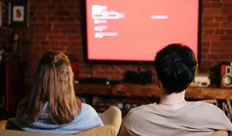 Kobieta i mężczyzna oglądający telewizję