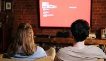 Kobieta i mężczyzna oglądający telewizję