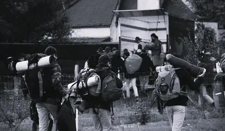 Migranci idący z bagażami