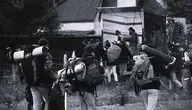 Migranci idący z bagażami