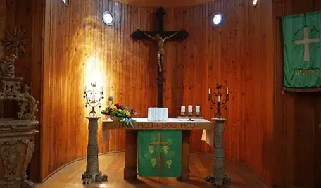 Wnętrze kościoła, ołtarz z krzyżem i świecami – zdjęcie ilustracyjne do artykułu o ograniczeniach wolności religijnej i modlitwy.
