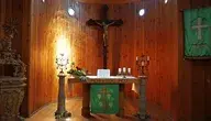Wnętrze kościoła, ołtarz z krzyżem i świecami – zdjęcie ilustracyjne do artykułu o ograniczeniach wolności religijnej i modlitwy.