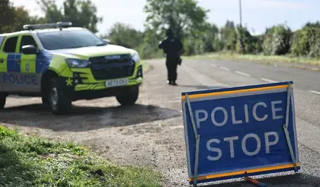 Uzbrojony funkcjonariusz policji przy kordonie bezpieczeństwa przed bazą RAF Fairford w Gloucestershire w Wielkiej Brytanii, 28 września 2026 r. Pięciu mężczyzn zostało aresztowanych pod zarzutem przestępstw związanych z materiałami wybuchowymi i terroryzmem po ogłoszeniu poważnego incydentu w bazie lotniczej w zachodniej Anglii.