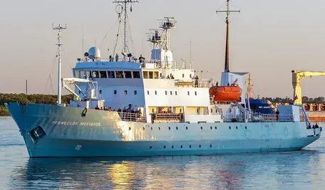 Statek badawczo-oceanograficzny Profesor Mołczanow (Профессор Молчанов) płynie po spokojnych wodach. Biało-niebieska jednostka z rosyjską nazwą na dziobie, wyposażona w nadbudówkę, maszty, łodzie ratunkowe i sprzęt badawczy, widoczna podczas rejsu w porcie
