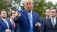 Donald Trump w niebieskim garniturze przemawia do dziennikarzy w otoczeniu polityków i liderów technologicznych przed Białym Domem.
