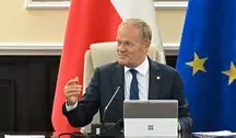 Premier Donald Tusk podczas posiedzenia Rady Ministrów na tle flagi Polski i Unii Europejskiej