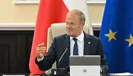 Premier Donald Tusk podczas posiedzenia Rady Ministrów na tle flagi Polski i Unii Europejskiej